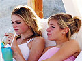 Kristin and Alex H. relax on the beach. What could be better than sipping on cold drinks while watching cute boys surf?